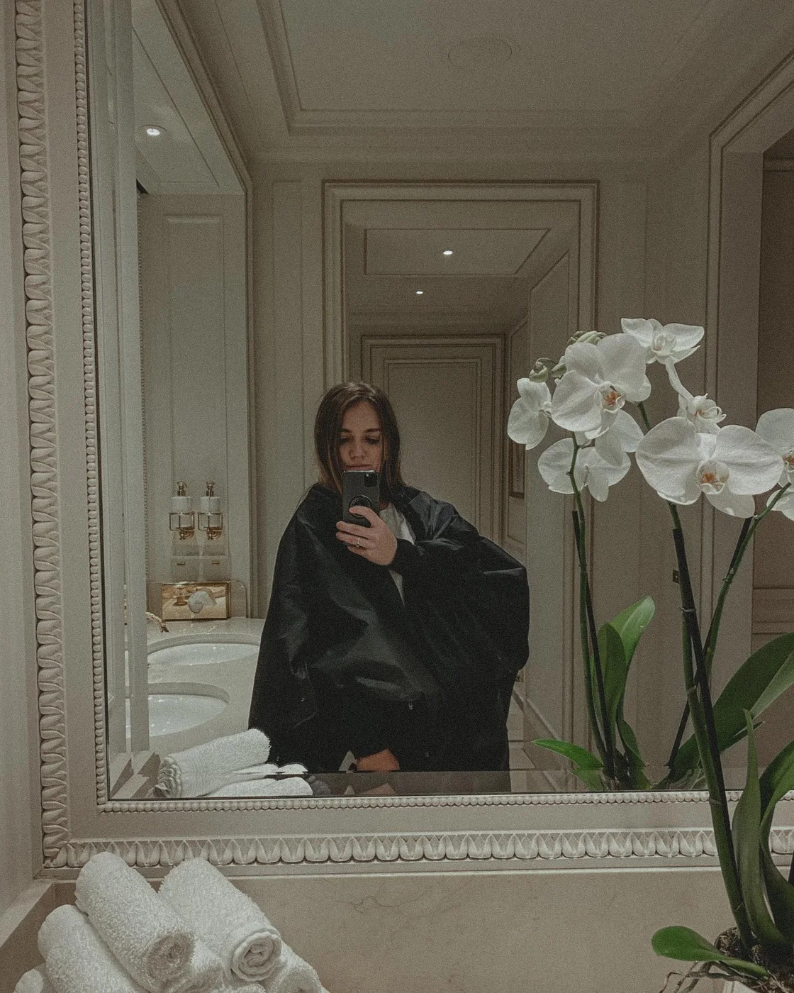 Mirror self-portrait in a classic hotel interior with white orchids
