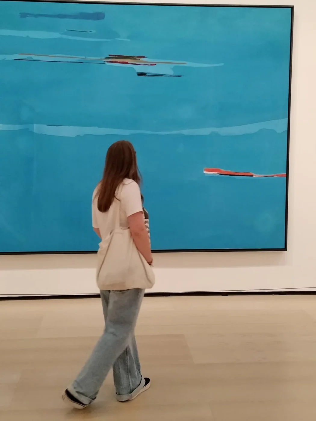 Cosmina in front of a large blue abstract painting in a museum